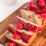 A sliced raspberry marble loaf on a wooden cutting board.