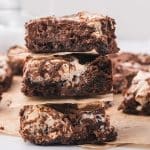 Three Nutella Fluff Brownies stacked on top of each other with parchment paper between them