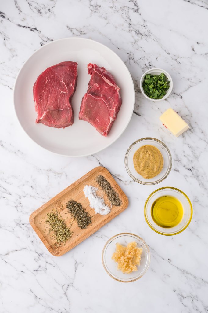 A mis-en-place of the ingredients for Air Fryer Steaks with Garlic Butter.