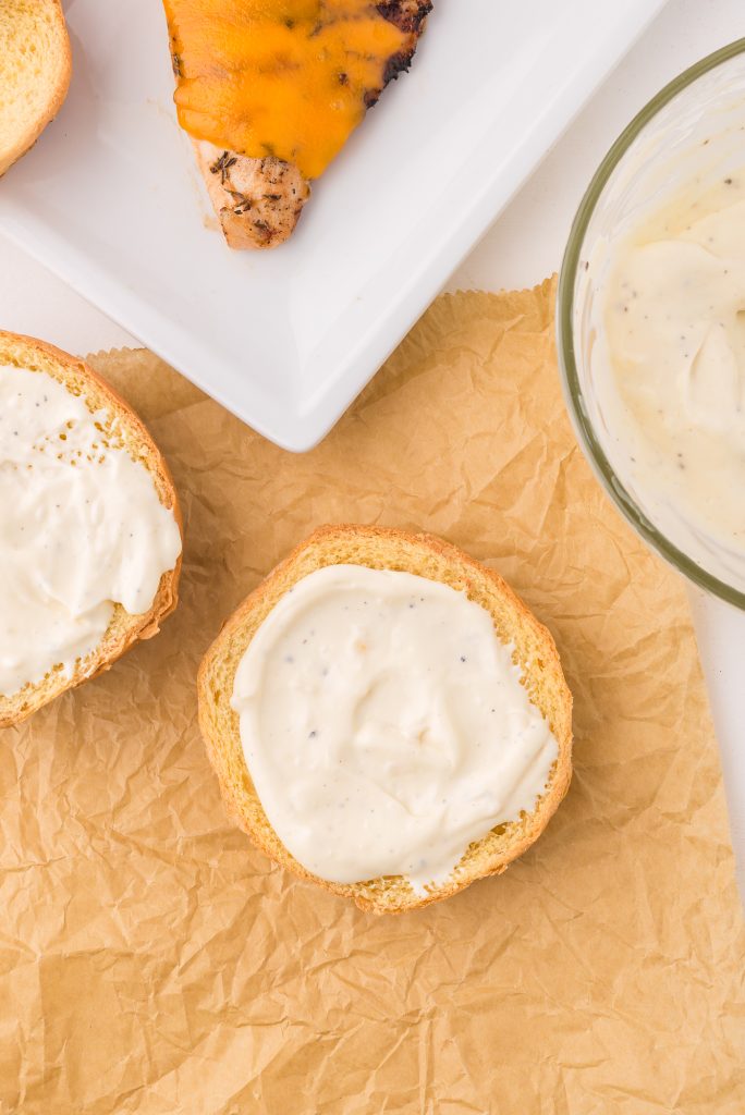 A split hamburger bun topped with garlic aioli.