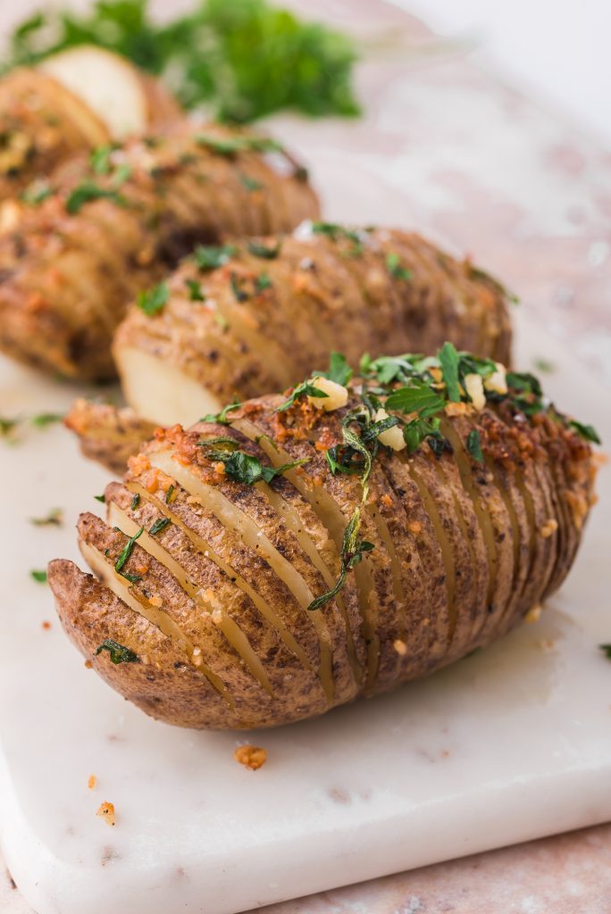 A closeup of a fully cooked Hasselback potato ready to serve.