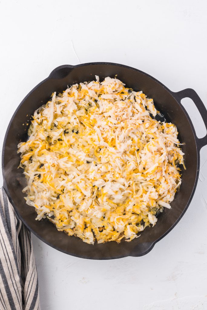 The grated potato mixture in a cast iron skillet.