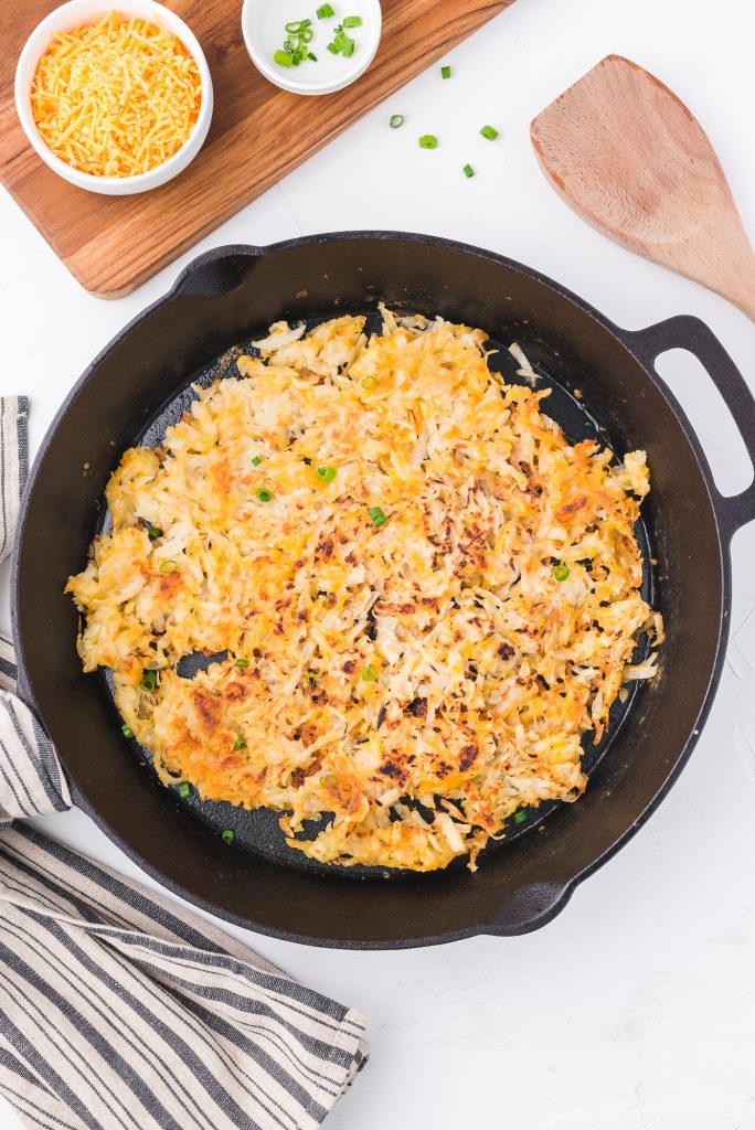 The completed Quick Cheesy Homemade Hash Browns in a cast iron skillet.