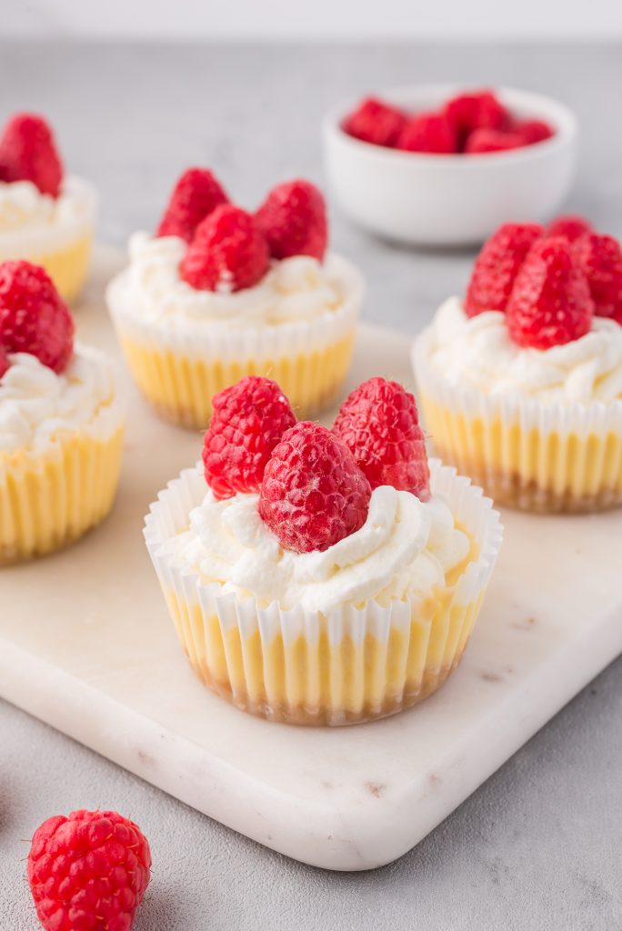 Five Mini Cheesecake Bites site on a marble serving board.