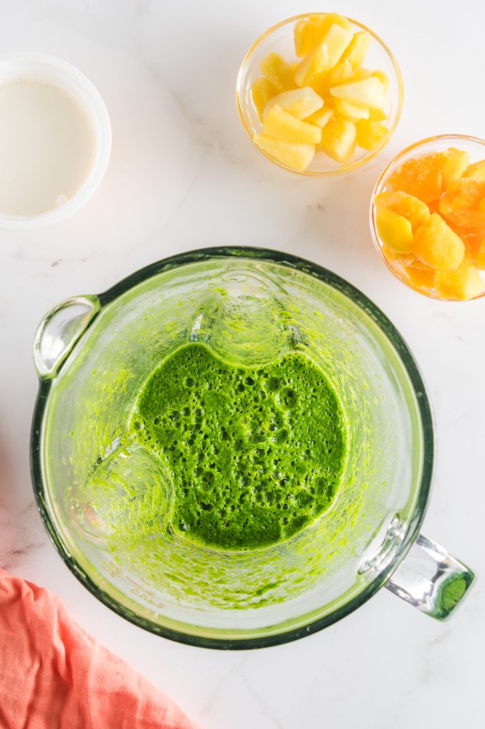 Spinach juice in a glass blender.