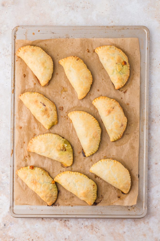 A baking sheet of baked Caprese Empanadas.