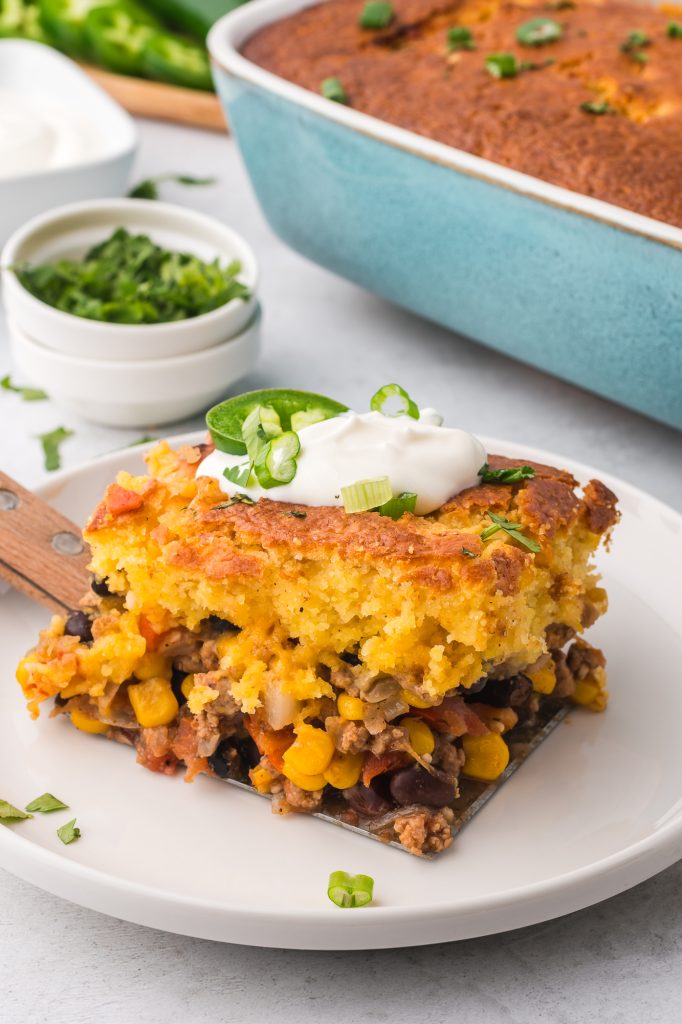 A slice of Jiffy Mexican Cornbread Casserole on a white plate.