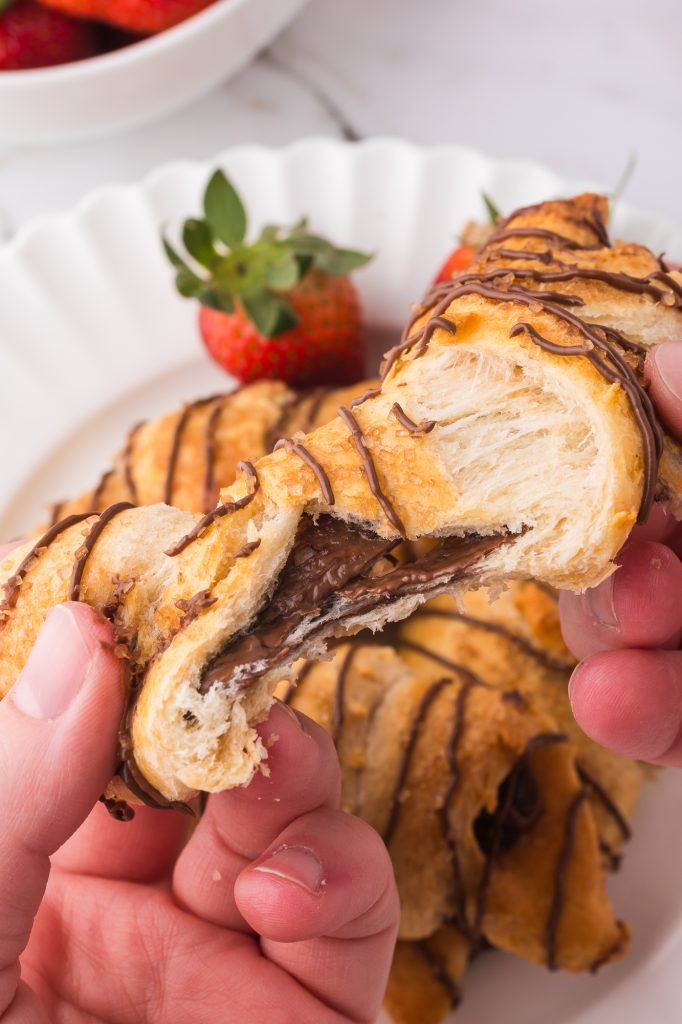 A close up of a Nutella-drizzled Nutella Croissant being pulled apart.