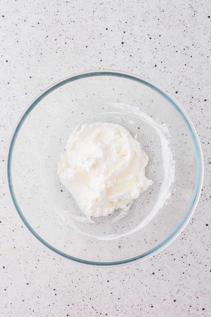 A glass bowl of whipped heavy whipping cream.