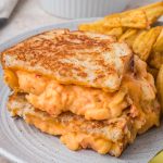 A Pimento Grilled Cheese Sandwich on a plate with potato wedges.