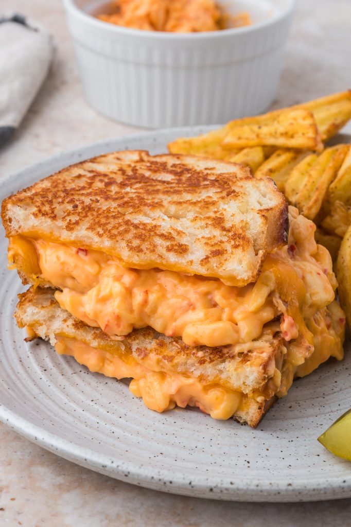 A Pimento Grilled Cheese Sandwich on a plate with potato wedges.