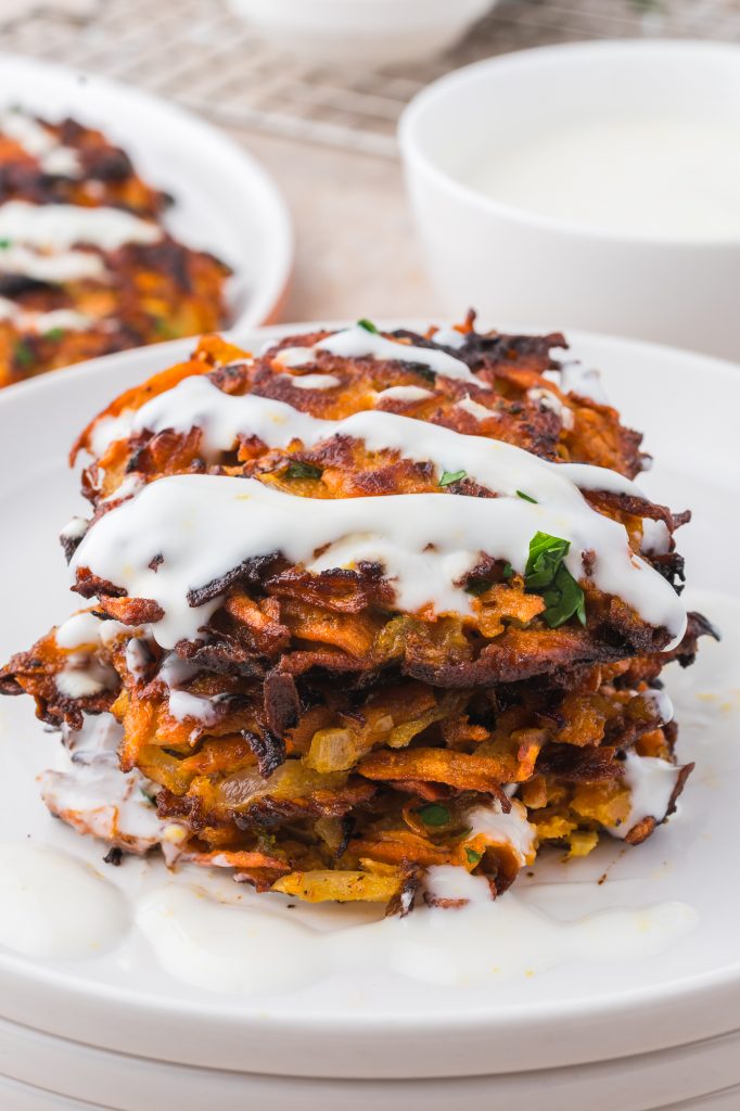 A stack of Sweet Potato Fritters with Honey Lemon Yogurt Sauce.