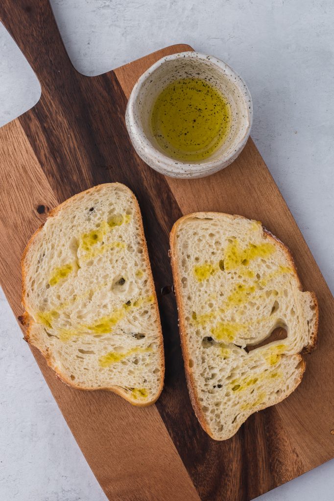 Two pieces of bread drizzled with olive oil.