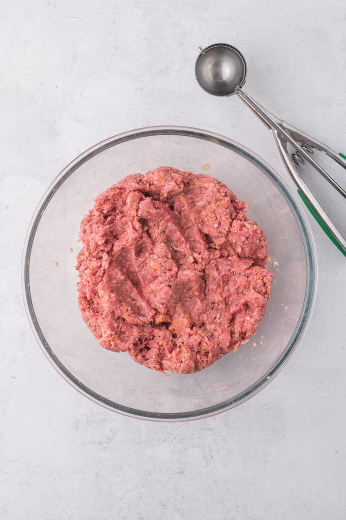 The mixed meatball mixture in a glass bowl.