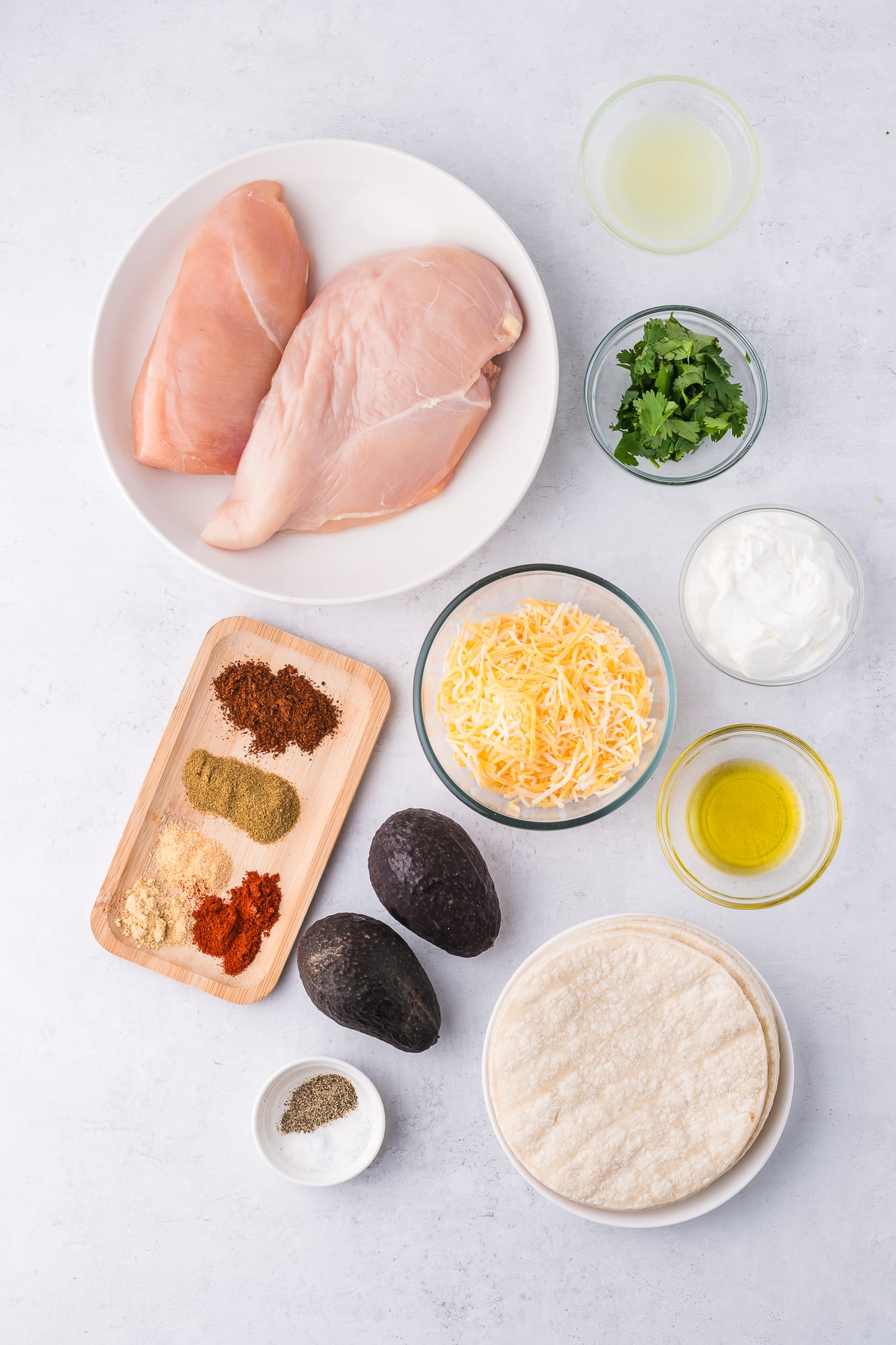 A mis-en-place of ingredients to make Baked Chicken Tacos with Avocado Lime Crema.