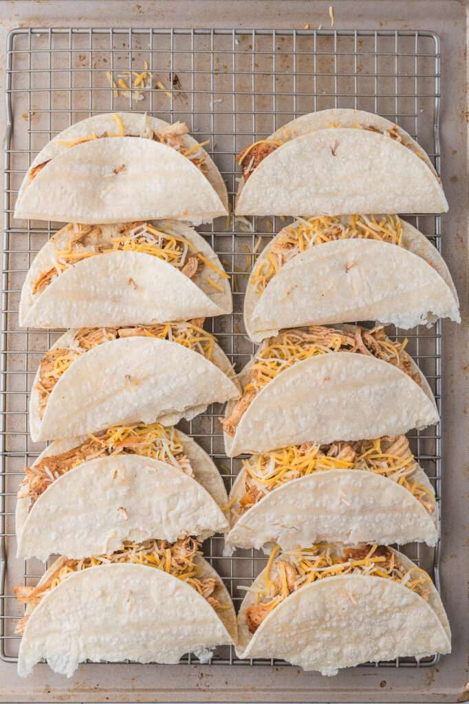 Ten Baked Chicken Tacos on a baking sheet before going into the oven.