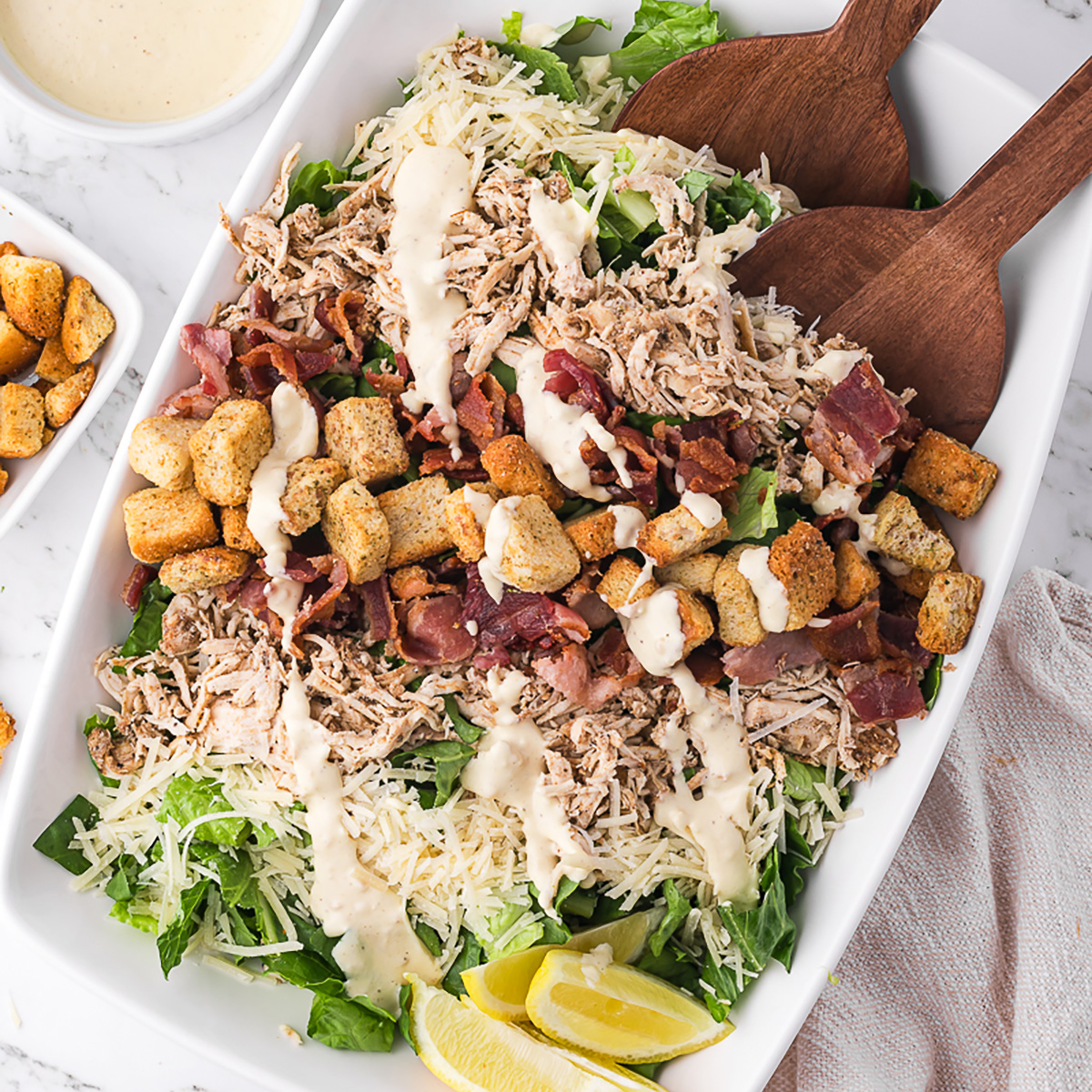 A large bowl of Chicken Bacon Caesar Salad.