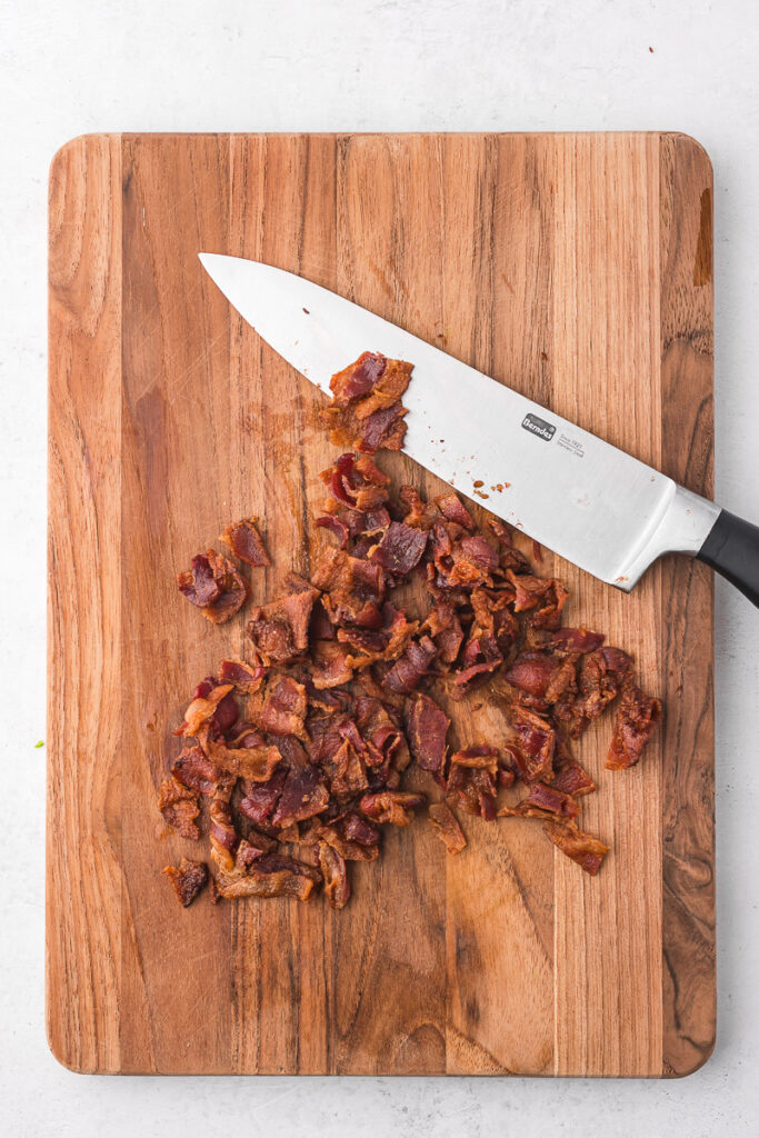 Some chopped bacon on a wooden cutting board.