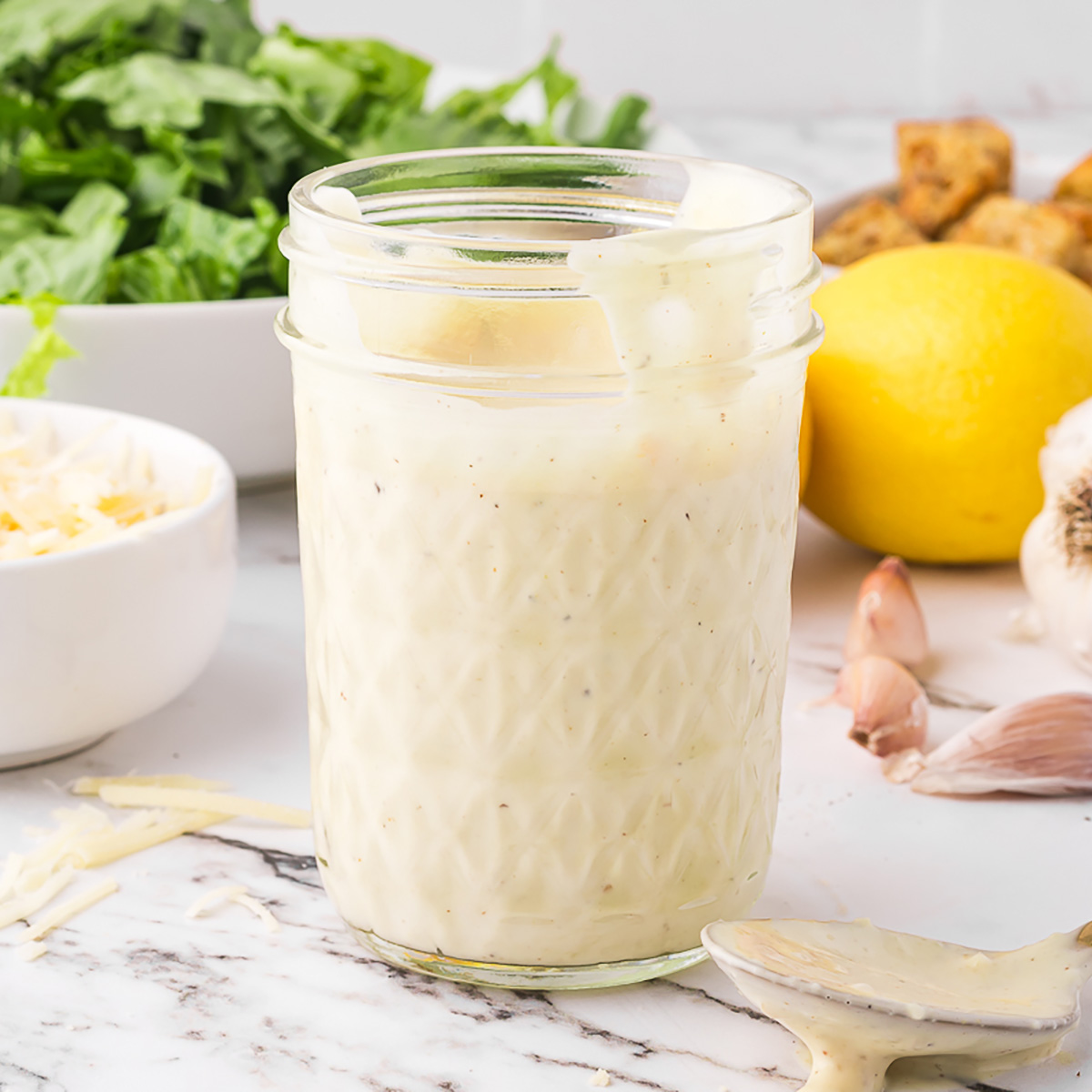 A mason jar of Homemade Caesar Dressing.