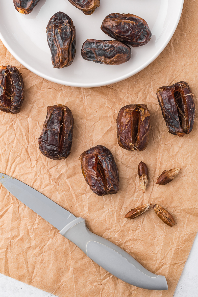 A close up of dried dates getting pitted.