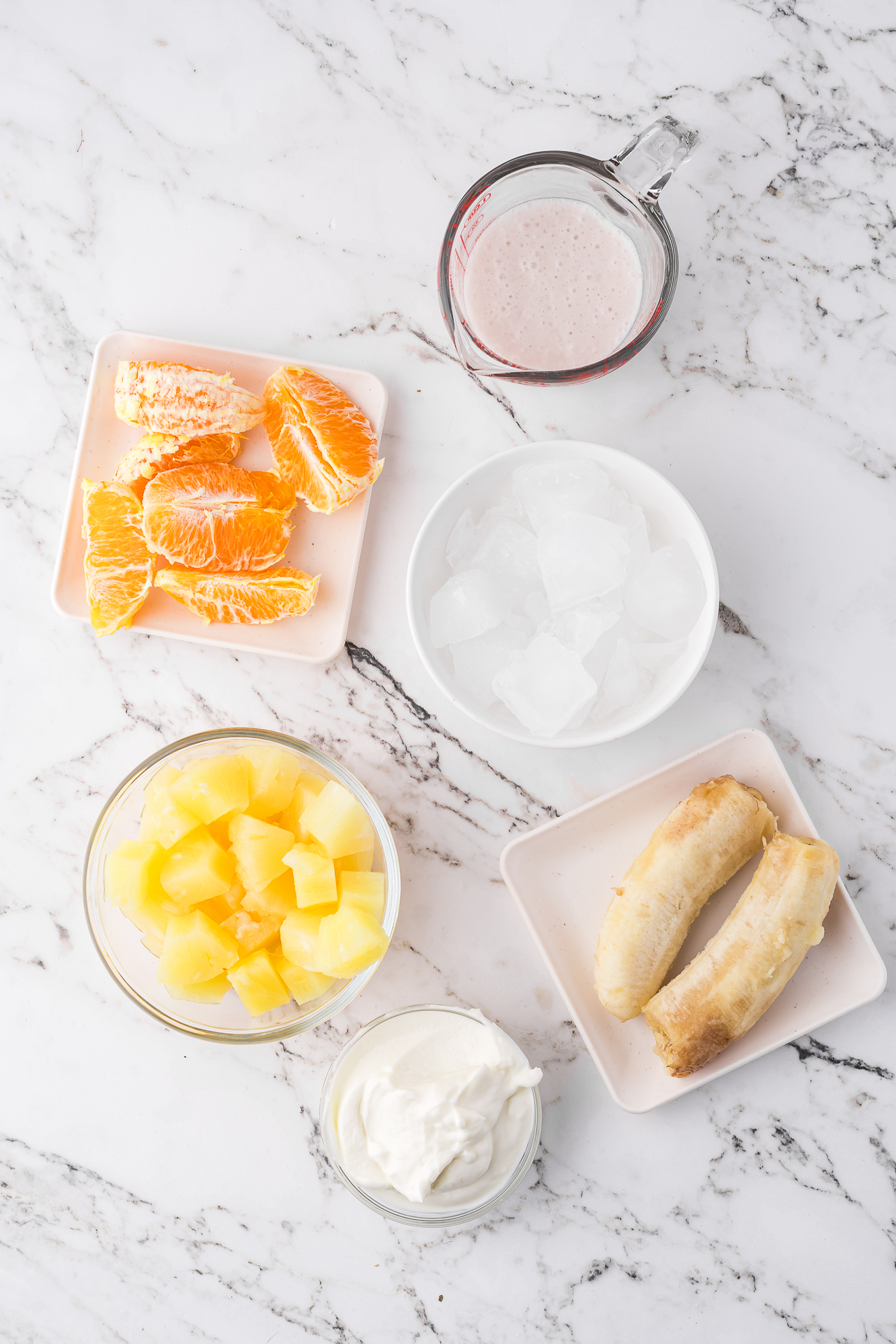 A mise en place of ingredients needed for Pineapple Orange Smoothies.