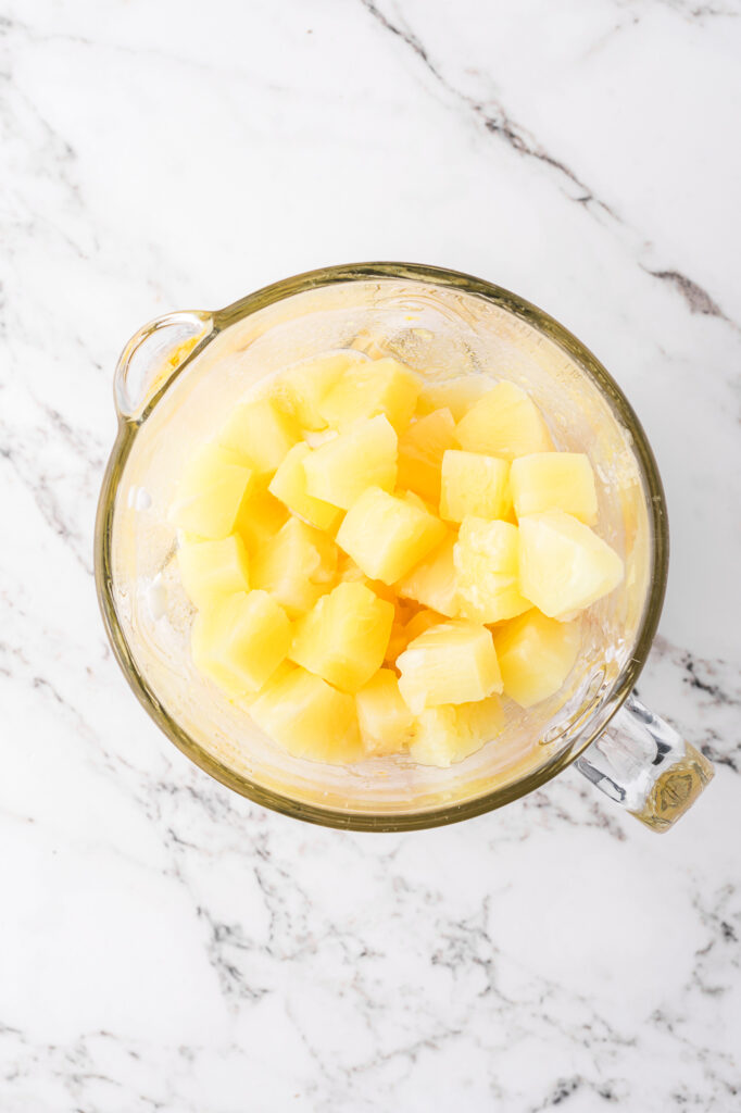 A top view of pineapple cubes in a blender.