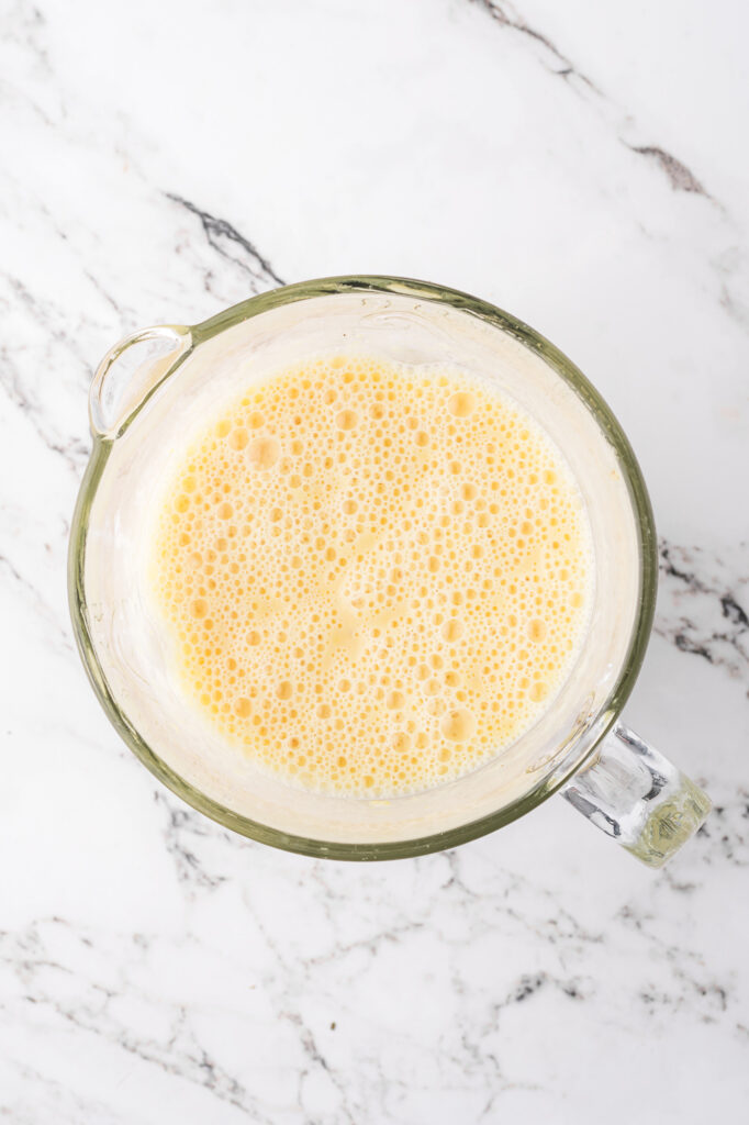 A top view of blended Pineapple Orange Smoothies in a blender.