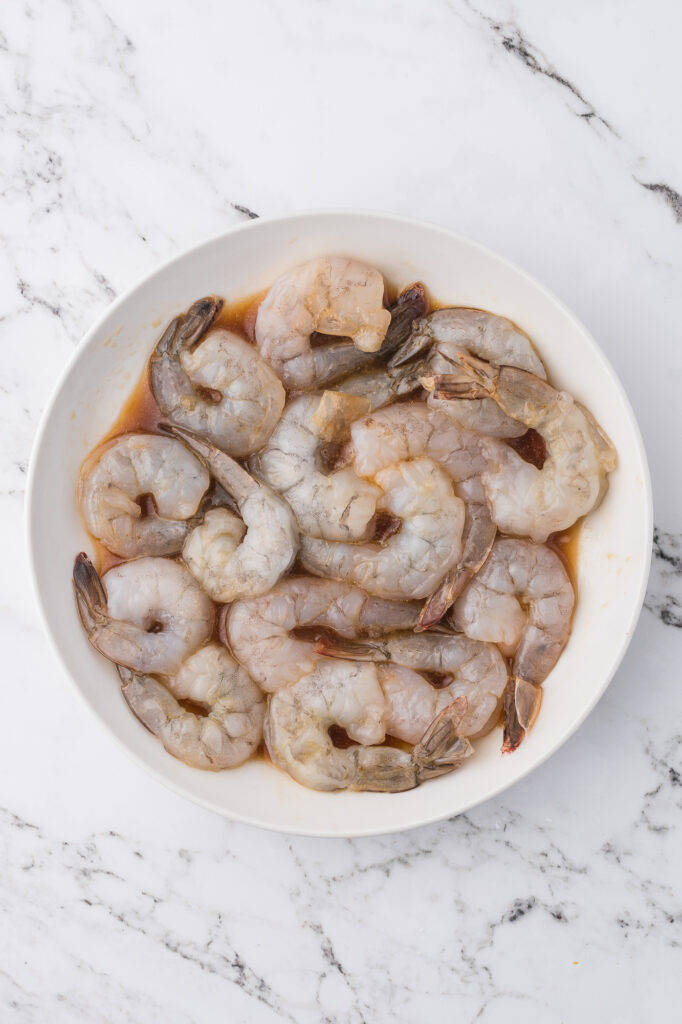 A bowl of raw shrimp in marinade for Shrimp Chow Mein.