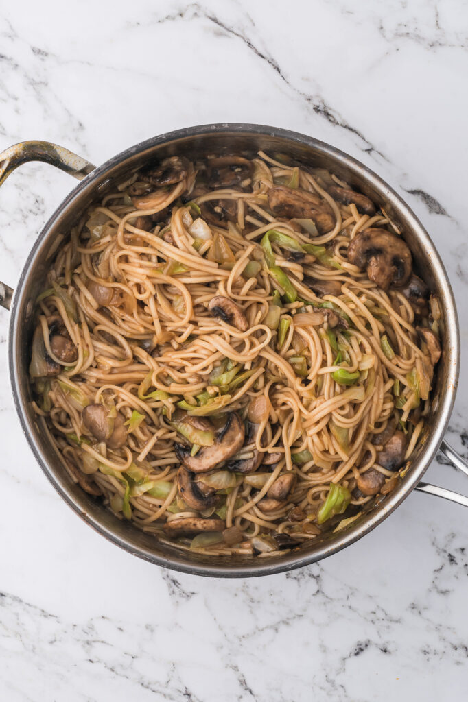 A medley of vegetables and noodles getting sauteed for Shrimp Chow Mein.