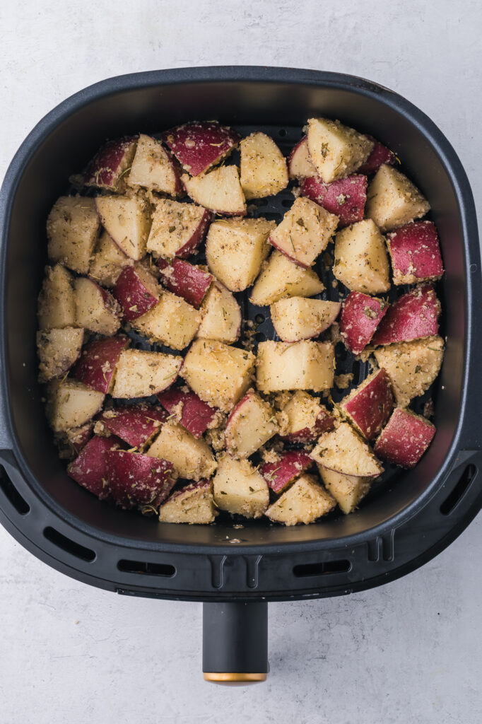 The raw Air Fryer Red Potatoes arranged in an air fryer basket.