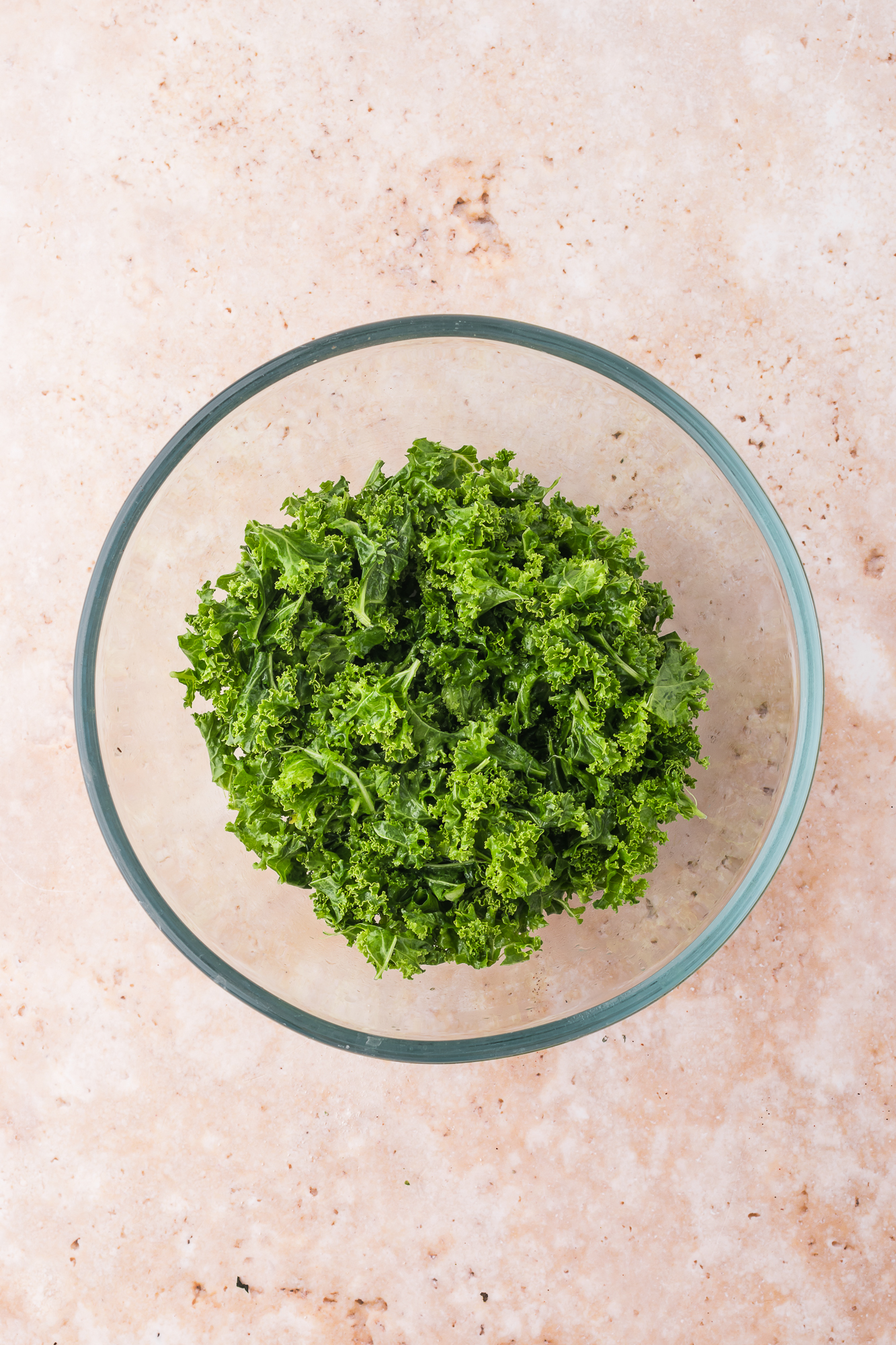 A glass bowl of kale for Kale Broccoli Salad.