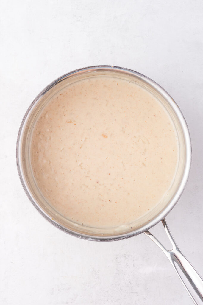 A saucepan containing all the uncooked ingredients for Rice Pudding with Condensed Milk.