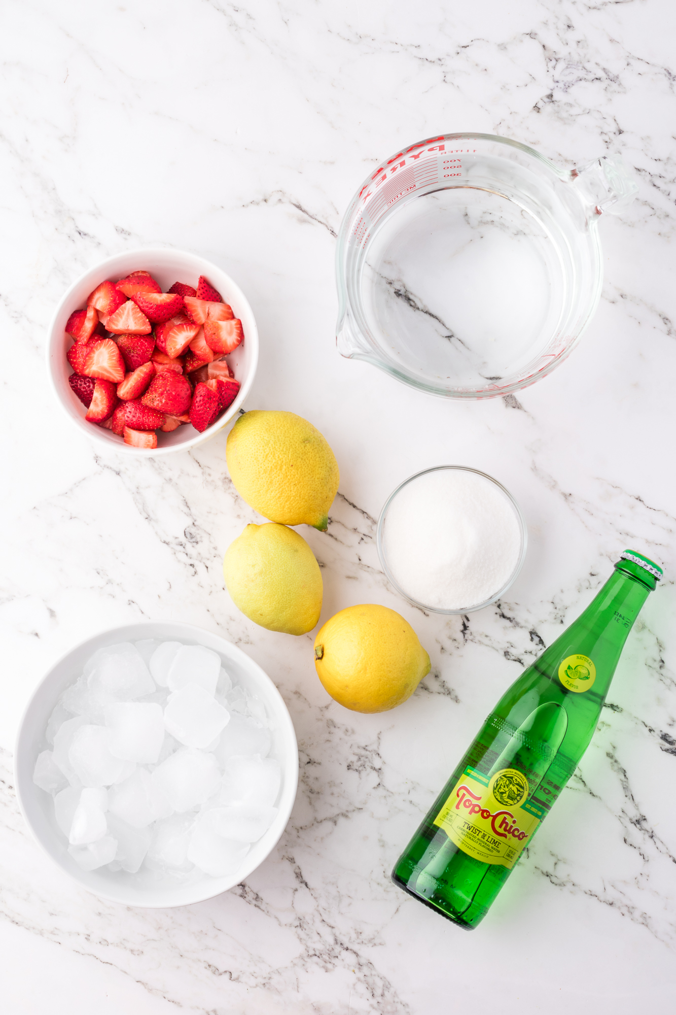 A mis-en-place of the ingredients for Sparkling Strawberry Lemonade.