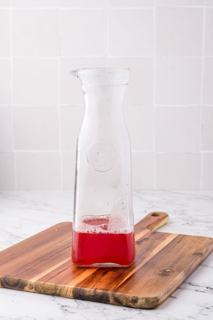 A carafe of strawberry juice.