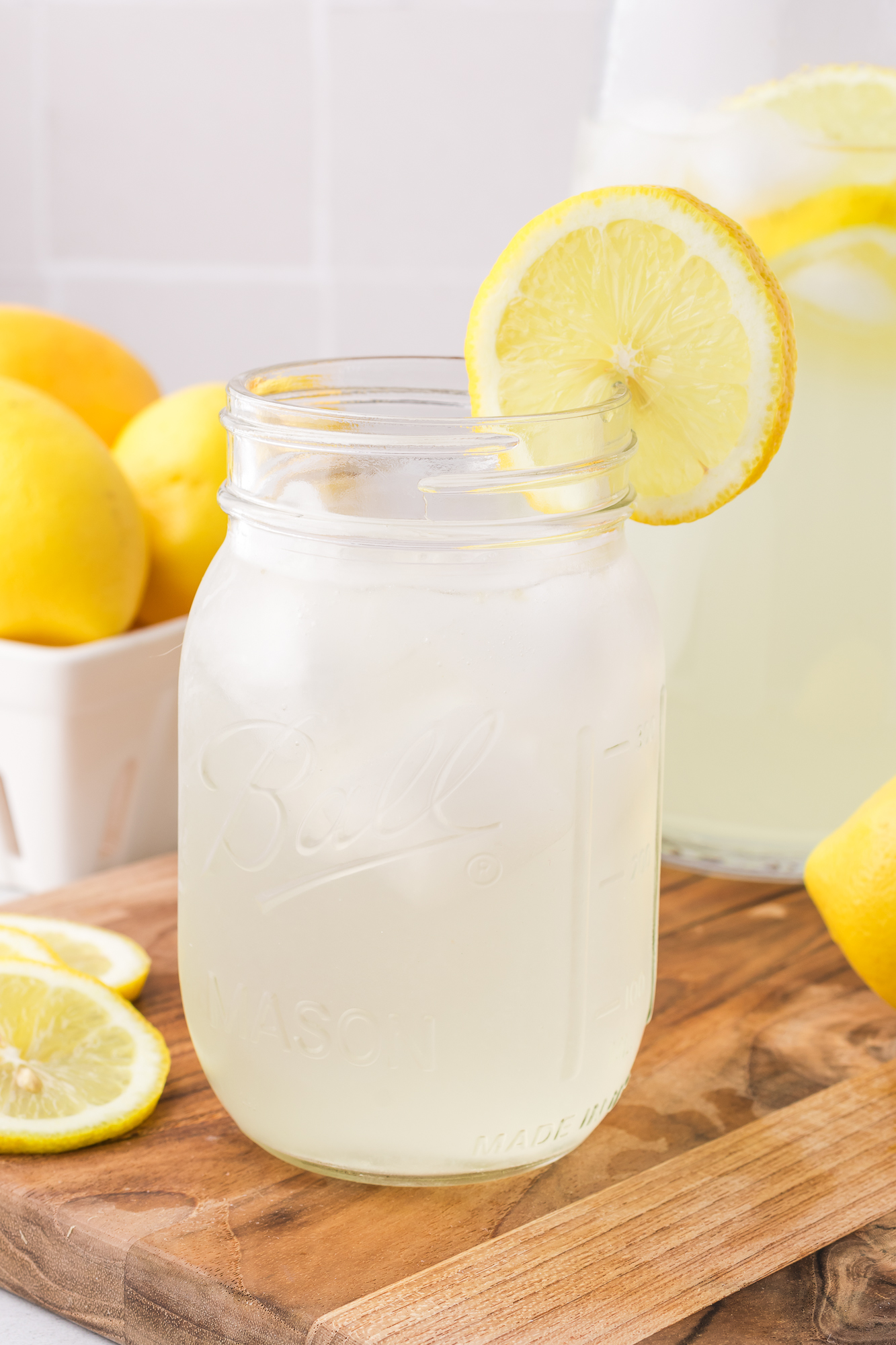 A mason jar of State Fair Lemonade with a lemon slice on the rim.