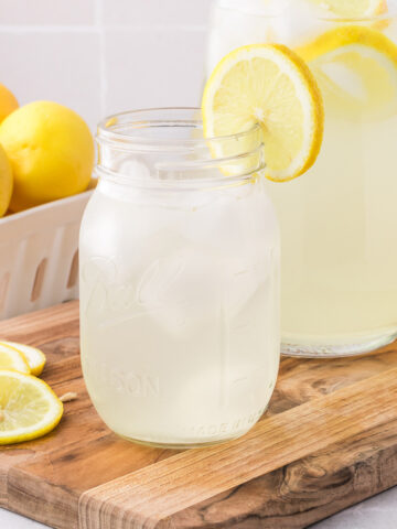 A mason jar of State Fair Lemonade with a lemon slice on the rim of the jar.