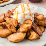 A plate of Air Fryer Apples with Bourbon topped with vanilla ice cream.