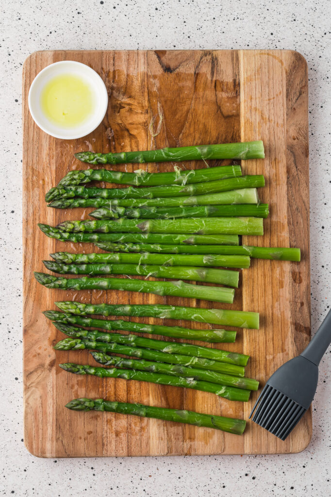 A cutting board with trimmed asparagus on it.