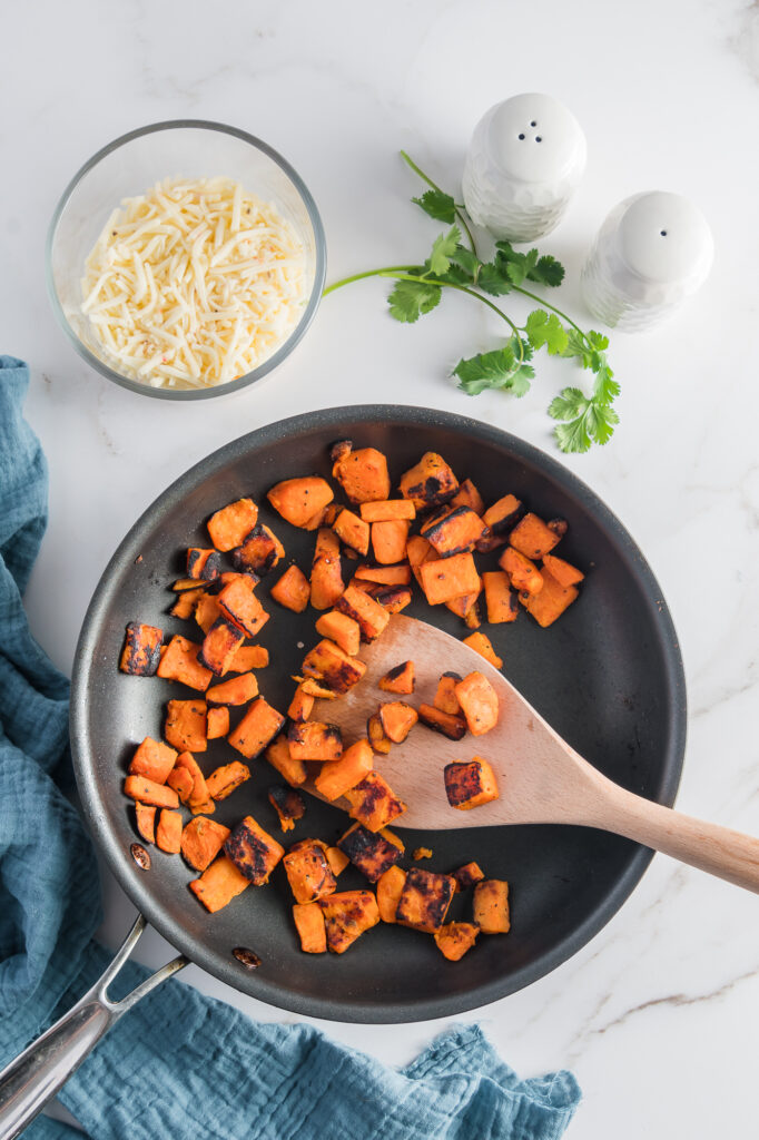 A pan of sauteed diced sweet potatoes.