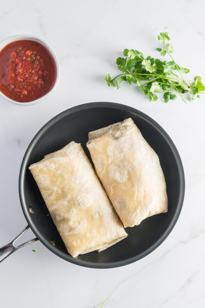 Two Sweet Potato Breakfast Burritos in a pan.