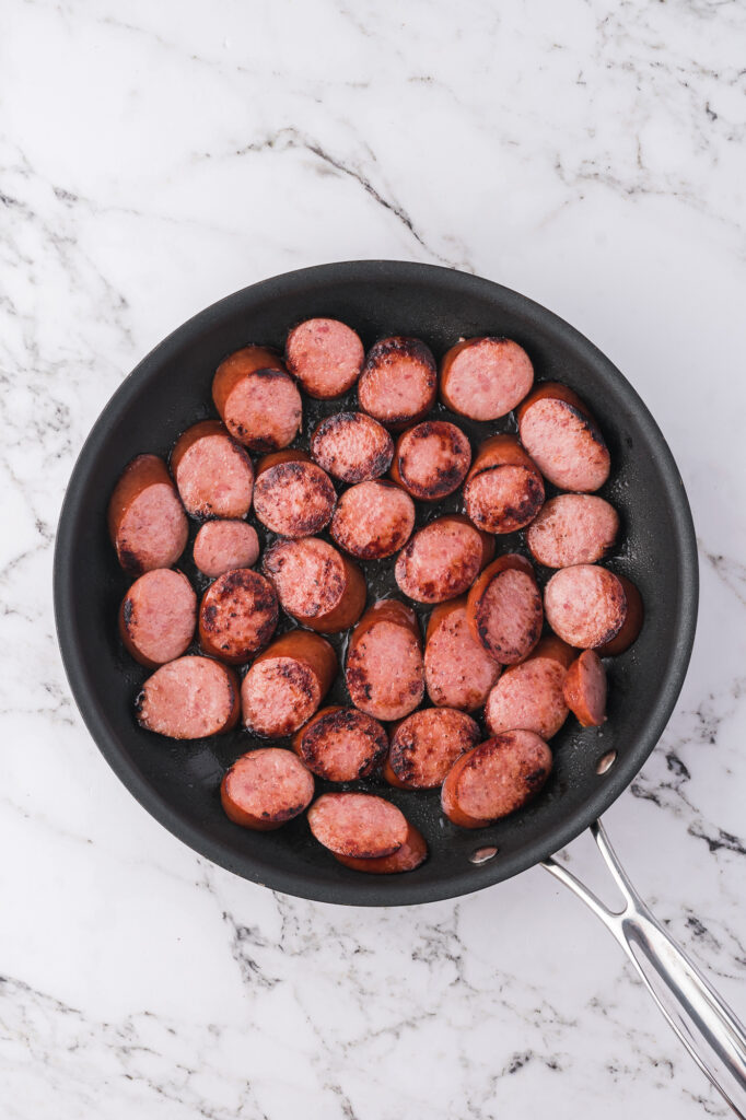 A pan of browned sliced sausages.