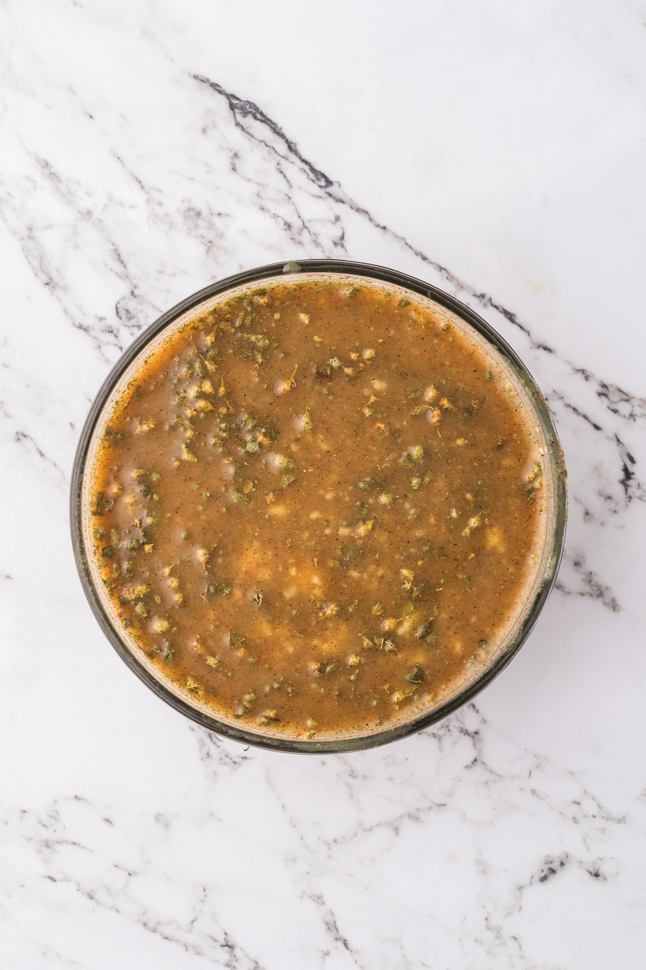 A glass bowl of the sauce for Slow Cooker Sausage Potato Casserole.