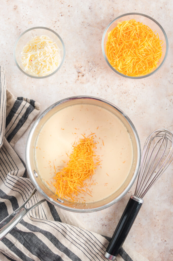 A mixture with unmelted cheese in a saucepan for Sheet Pan Nachos.