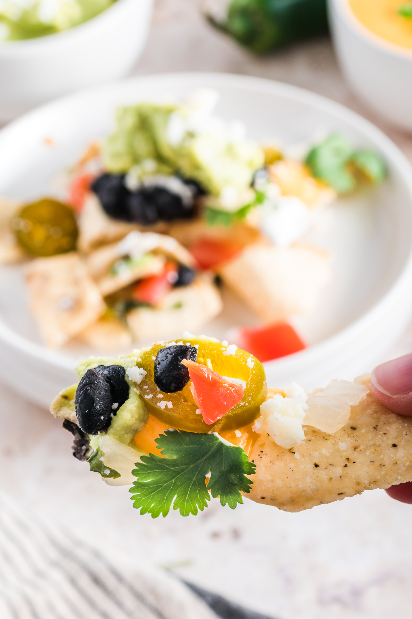 A close-up of one chip of Sheet Pan Nachos.