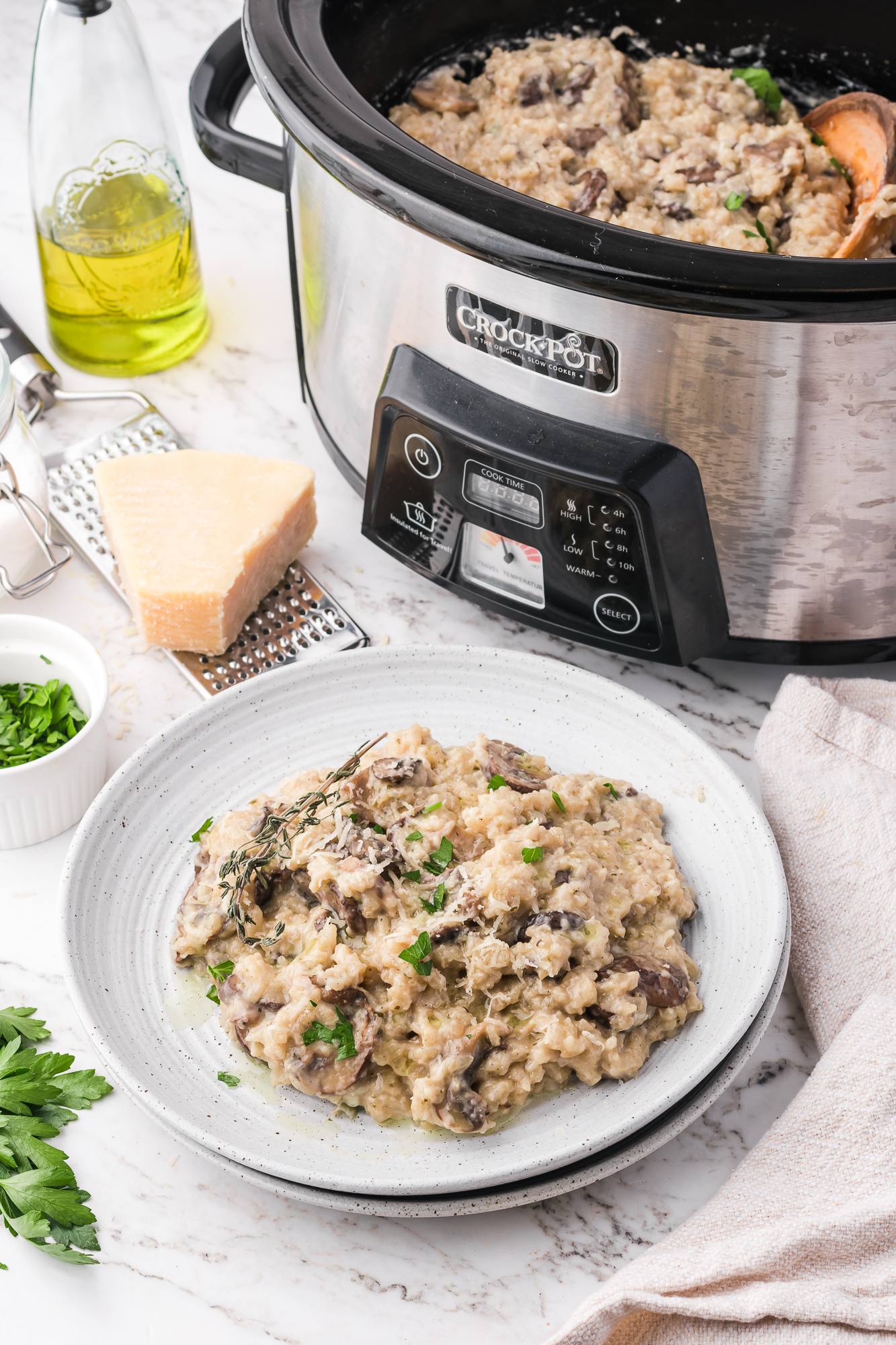 A plate of Slow Cooker Mushroom Risotto in front of a slow cooker.