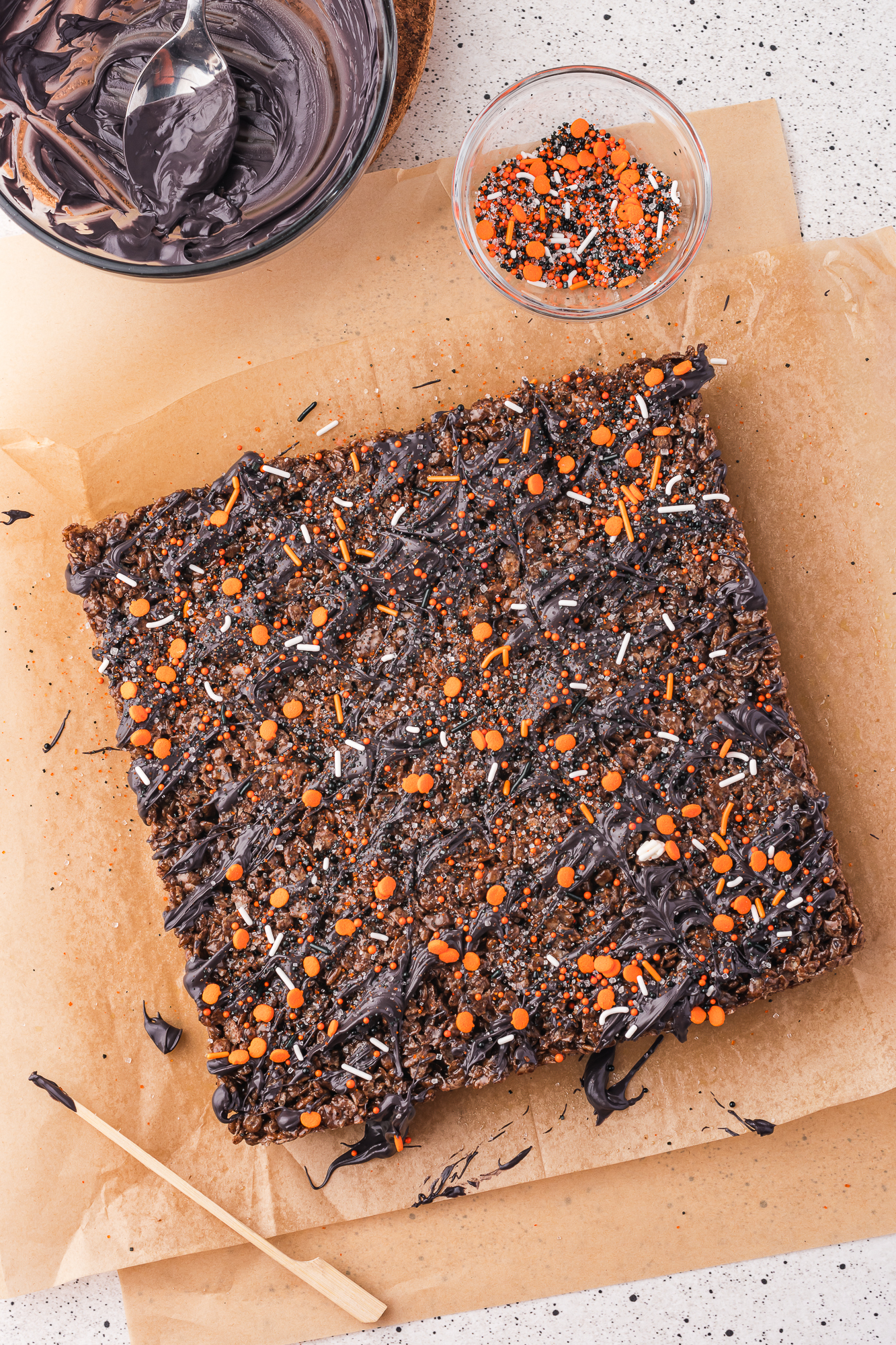 The whole Spooky Cocoa Pebbles Treats piece removed from the brownie pan, drizzled with the candy melts, and topped with spooky sprinkles.