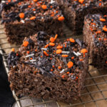 Sliced Spooky Cocoa Pebbles Treats on a cooling rack.