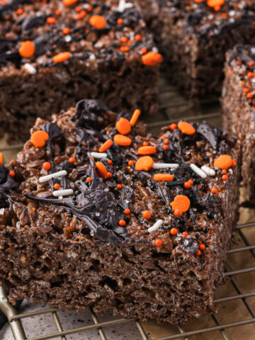 Sliced Spooky Cocoa Pebbles Treats on a cooling rack.