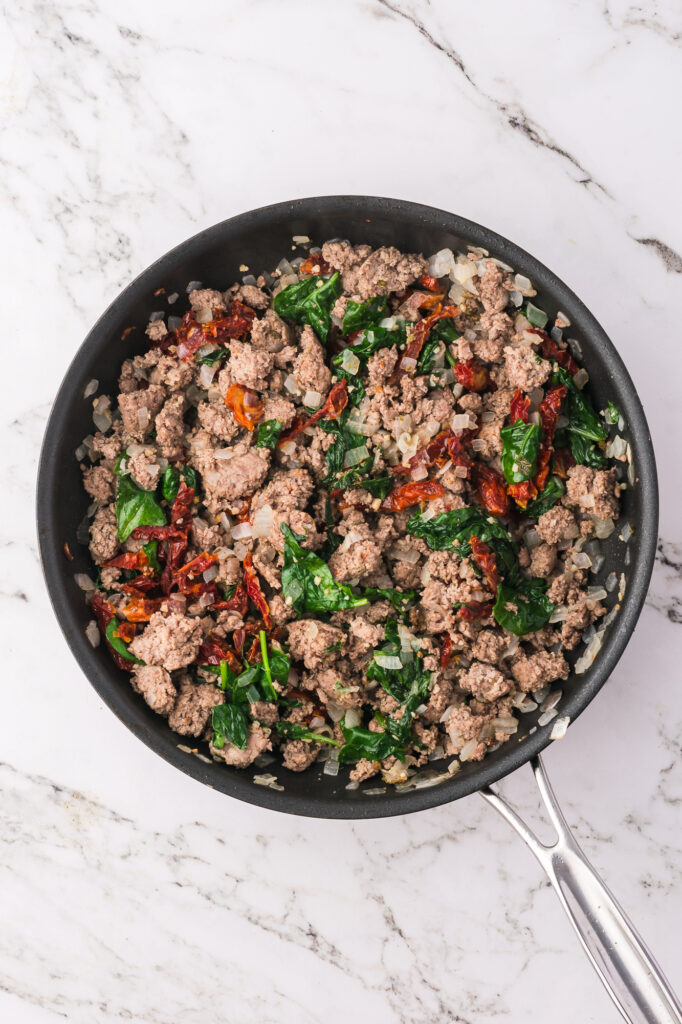 A skillet with a turkey and vegetable mixture.