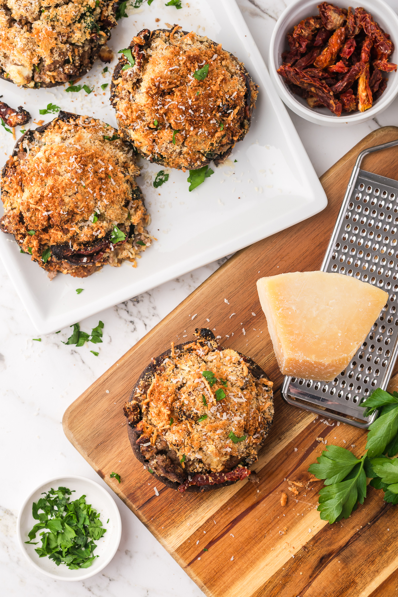 Three Stuffed Portobello Mushrooms next to a grater grating cheese.